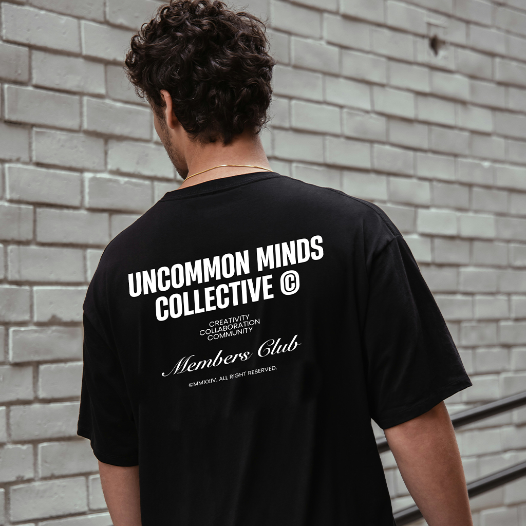 Man photographed from the back, wearing a black t-shirt by Uncommon Minds Collective (UMC). Minimalist and sleek streetwear style for men. Shop UMC for modern, everyday black t-shirts.